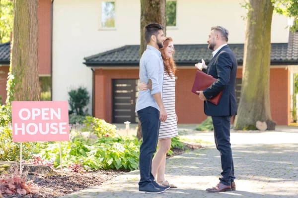 Real estate consultant inviting couple — Stock Photo, Image