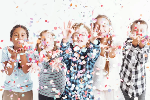 Niños soplando confeti —  Fotos de Stock