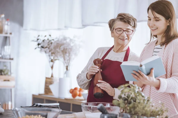 Jeune femme tenant livre de cuisine — Photo