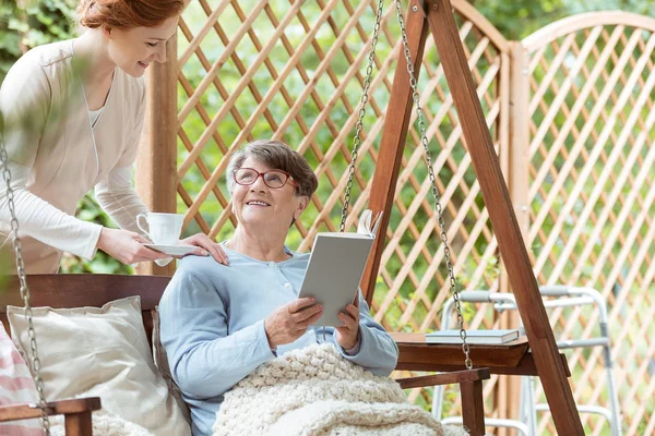 Elder sitting on hanging bench