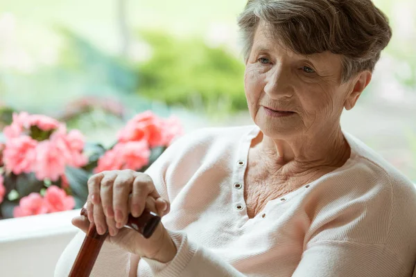 Elder sitting on white sofa — Stock Photo, Image