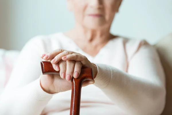 Elder holding walking cane — Stock Photo, Image