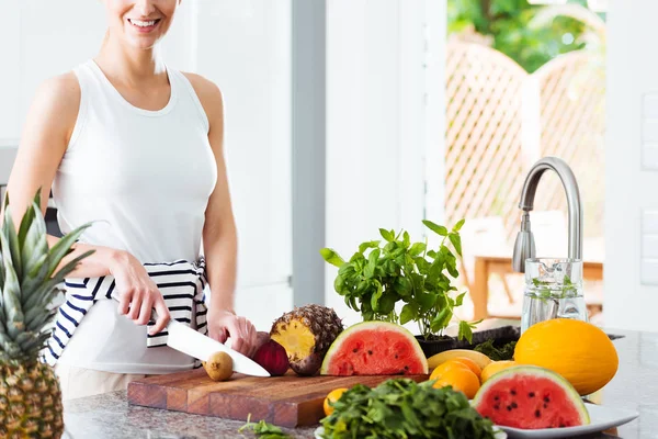 Vrouw snijden vruchten in keuken — Stockfoto