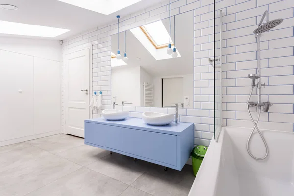 Світла ванна кімната з синім шафою — стокове фото