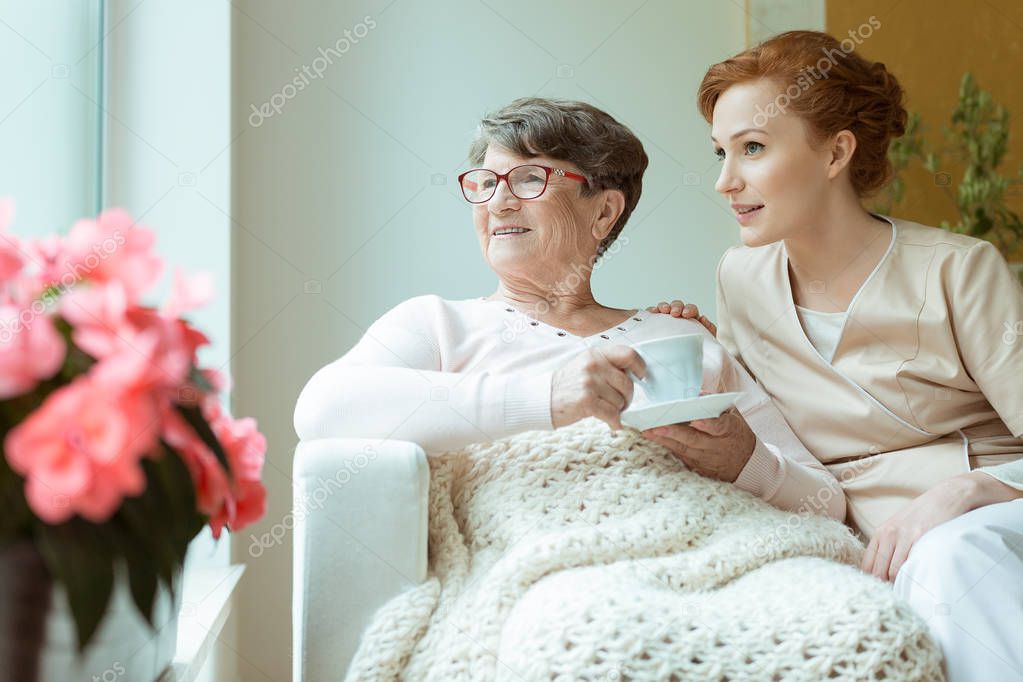 Nurse sitting with elder woman