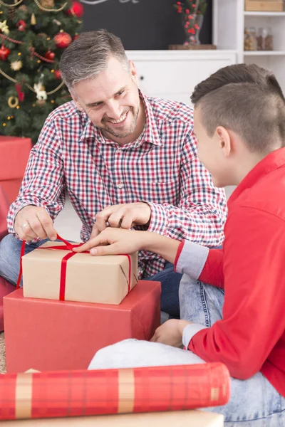 Lächelnder Vater packt Weihnachtsgeschenk aus — Stockfoto