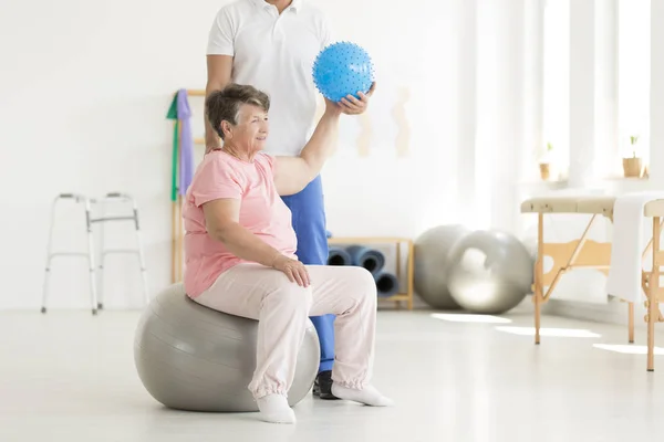 Senior woman using blue ball — Stock Photo, Image