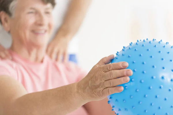 Mujer mayor sosteniendo bola azul — Foto de Stock