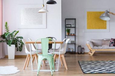 Çeşitli sandalyeler masanın tarafından ayakta