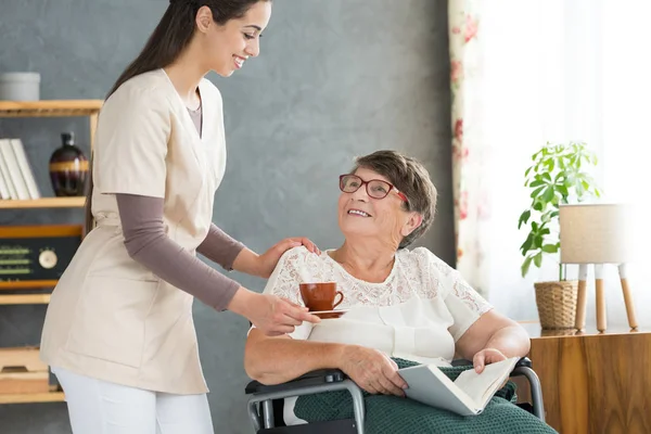 Jonge verpleegster en oudere vrouw — Stockfoto