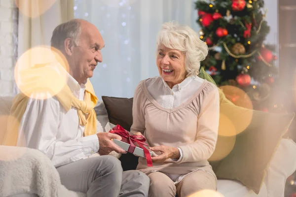 Senior female person giving present to her husband — Stock Photo, Image