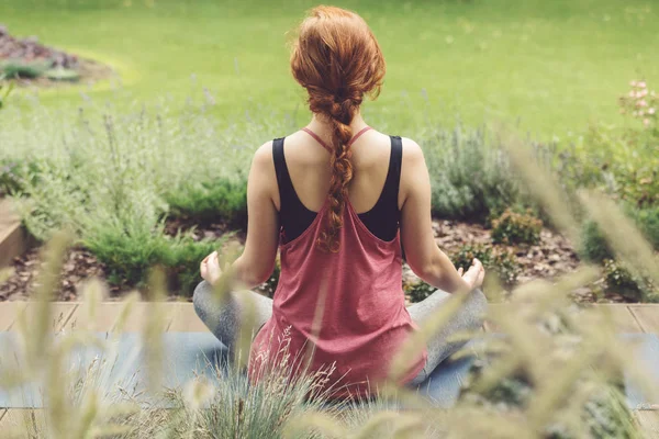 Концентрированная женщина на коврике для йоги — стоковое фото