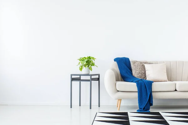 Blauwe deken op beige sofa — Stockfoto