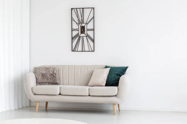 Металевий дизайнерський годинник над диваном — стокове фото