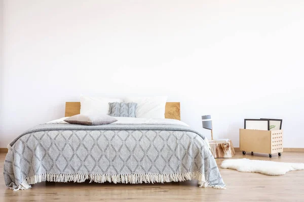 Wooden crate next to bed — Stock Photo, Image