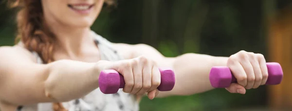Vrouw uit te oefenen met paarse halters — Stockfoto