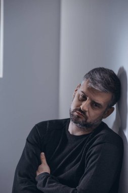 Üzgün adam duvara yaslanmış