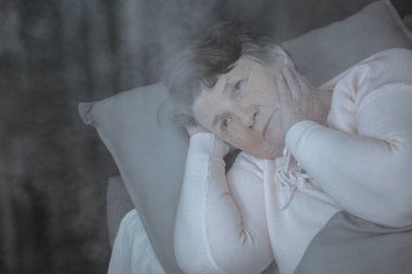 Düşünceli üst düzey kadın yatakta