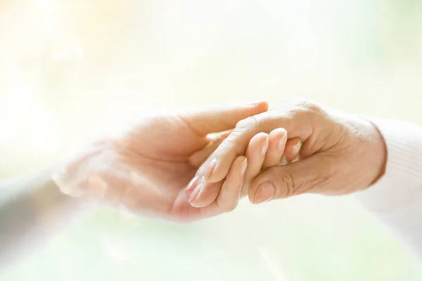 Young hand holding elderly hand — Stock Photo, Image