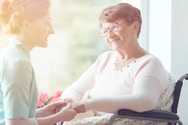 Joven voluntaria y anciana — Foto de Stock