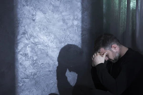 Депрессивный мужчина средних лет держит голову — стоковое фото