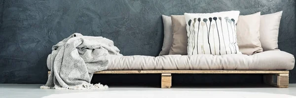 Деревянная кровать с узорной подушкой — стоковое фото
