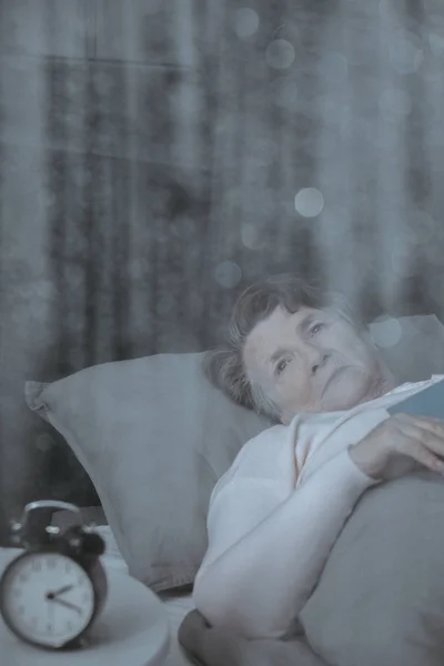 Сонная бабушка в постели — стоковое фото