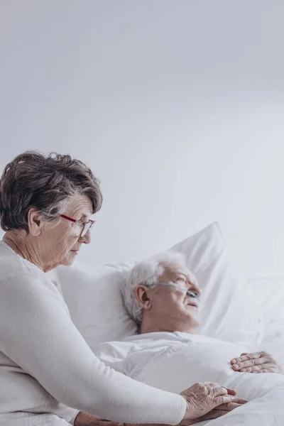 Senior vrouw ondersteunende zieke man — Stockfoto