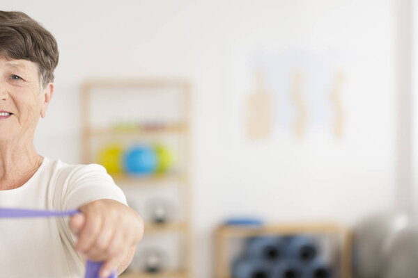 Старшая женщина тренирует мышцы плеча
