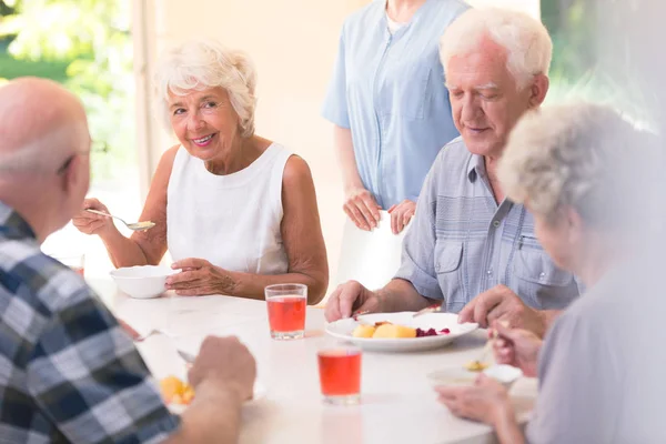 Mujer mayor sonriente comiendo sopa — Foto de Stock