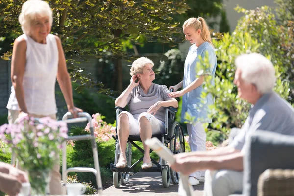 Gehandicapte bejaarde vrouw in tuin — Stockfoto