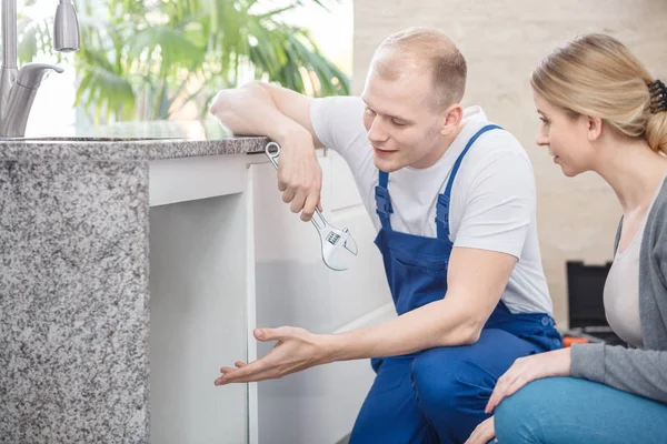 Plumber with wrench and housewife — Stock Photo, Image