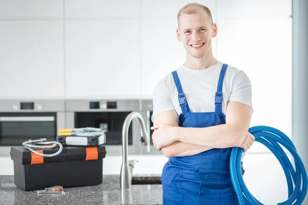 Lachende loodgieter met blauwe buizen — Stockfoto