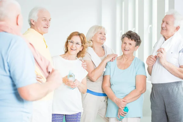 Anziani discutendo routine di allenamento — Foto Stock