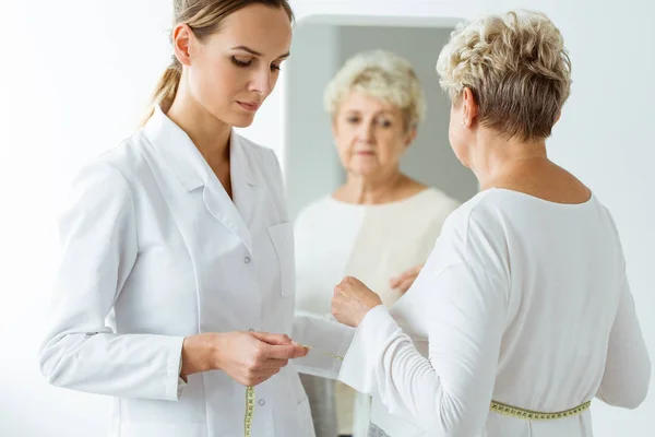 Nutricionista midiendo la circunferencia corporal del paciente — Foto de Stock