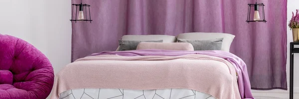 King-size bed against violet curtains