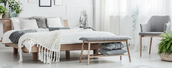 Houten bed in eenvoudige slaapkamer — Stockfoto