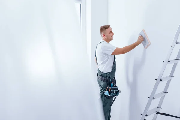 Pintor alisando a parede — Fotografia de Stock