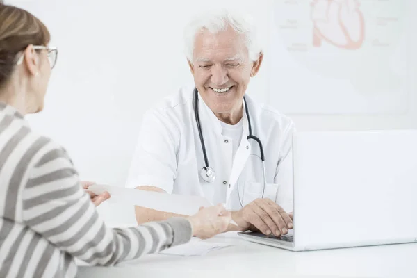 Усміхнений лікар використовує ноутбук — стокове фото