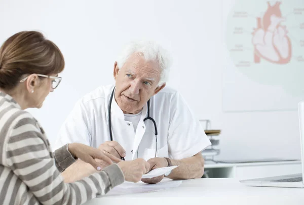Elderly cardiologist consulting tests results — Stock Photo, Image