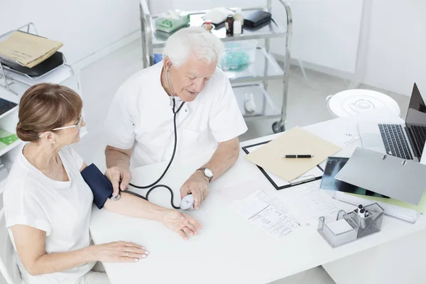 Médico que mede a pressão arterial — Fotografia de Stock