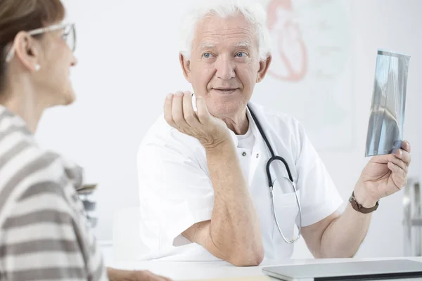 Médico senior sosteniendo imagen de rayos X — Foto de Stock