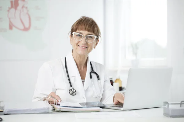 Lachende arts met behulp van laptop — Stockfoto