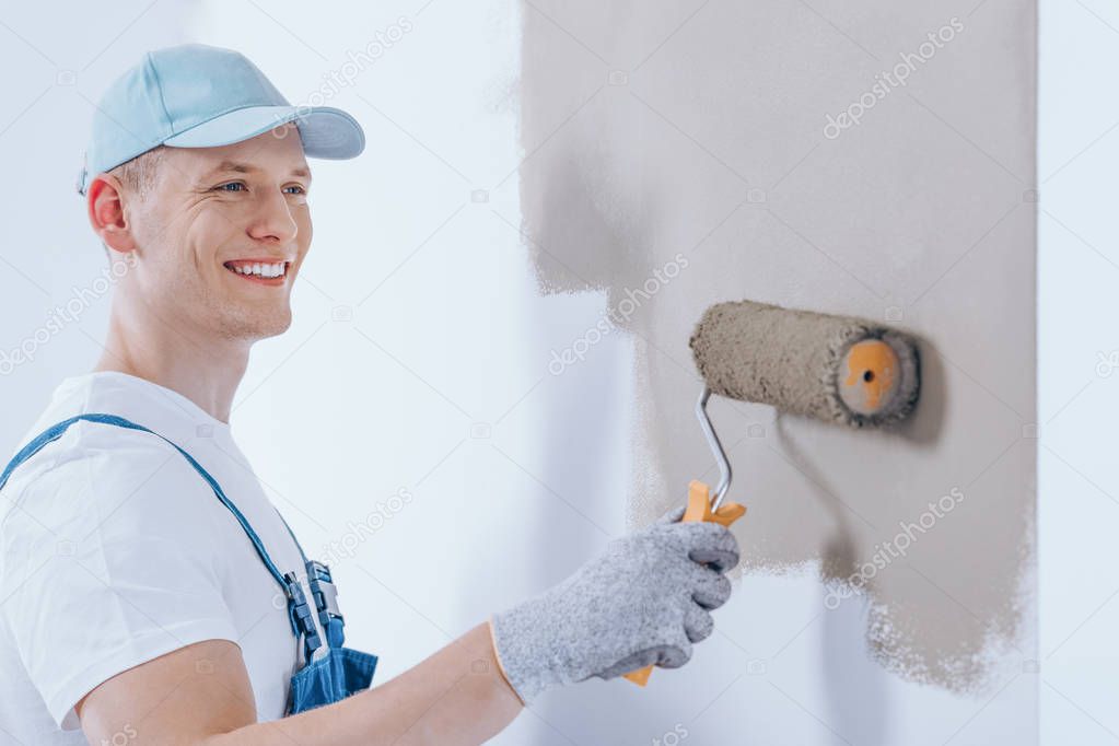 Happy painter painting the wall