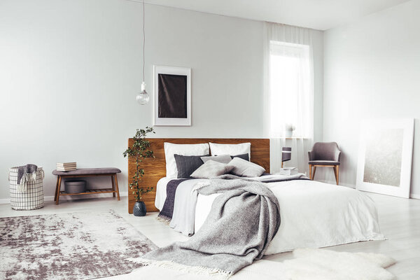 Темный плакат в светлой спальне
