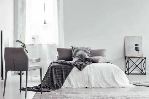 Beyaz yatak odasında gri sandalye — Stok fotoğraf