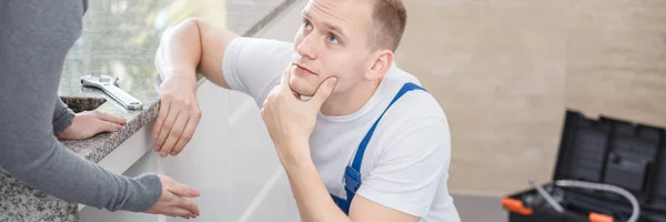 Handyman ouvindo dona de casa — Fotografia de Stock