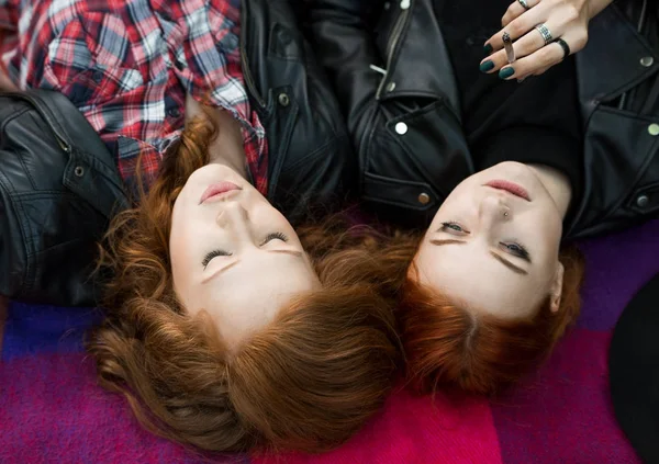 Hermanas rebeldes tumbadas sobre una manta — Foto de Stock