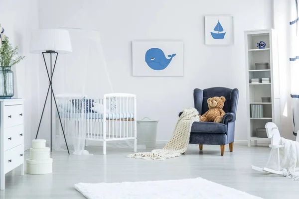 扶手椅和台灯之间的婴儿床 — 图库照片