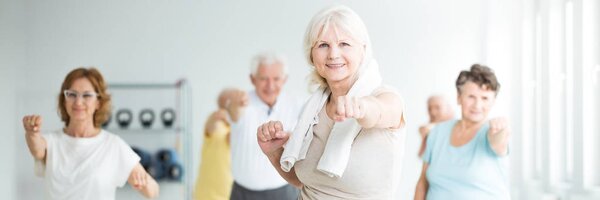 Senior sportswoman exercising with friends